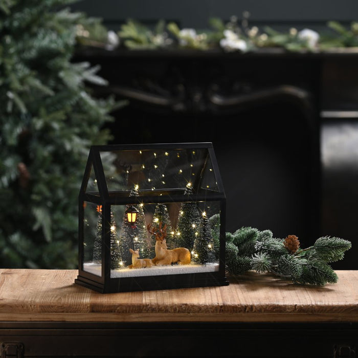 Lit Glass House with Reindeer and Trees