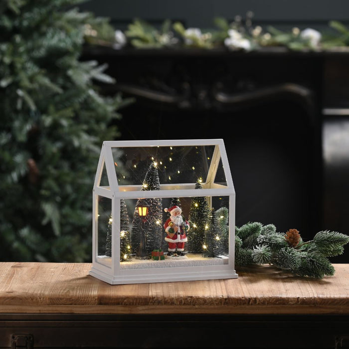 Lit Glass House with Santa and Trees